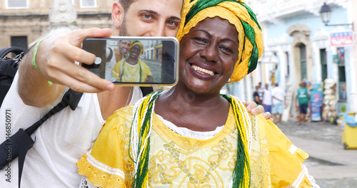 Tourist taking a selfie with a Baiana in the old colonial district of Salvador, Brazil