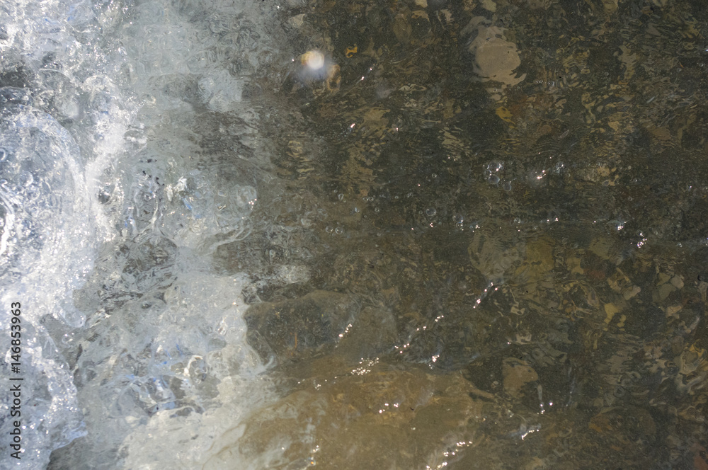 sea pebble beach with multicoloured stones, waves with foam sea pebble beach with multicoloured stones, waves with foam