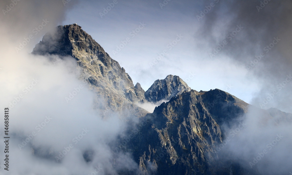 Cloud covered Lomnicky peak, with observatory, and Lomnicky ridge, Kezmarsky peak in the background, High Tatras, Tatra National Park, Slovakia, in a sunny autumn day, from Slavkovsky peak Cloud covered Lomnicky peak, with observatory, and Lomnicky ridge, Kezmarsky peak in the background, High Tatras, Tatra National Park, Slovakia, in a sunny autumn day, from Slavkovsky peak
