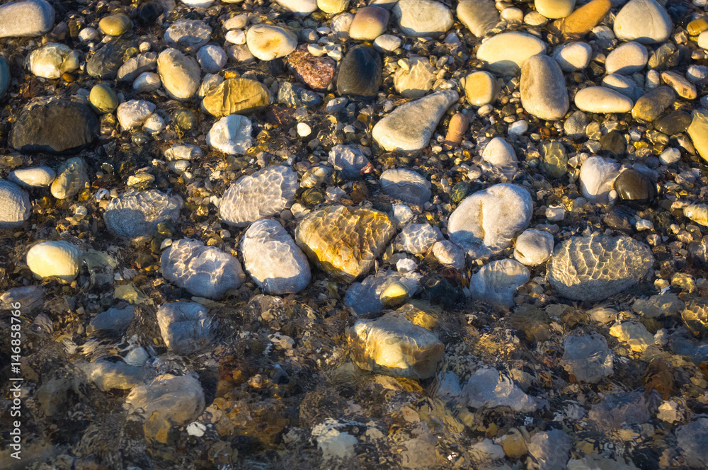sea pebble beach with multicoloured stones, waves with foam sea pebble beach with multicoloured stones, waves with foam