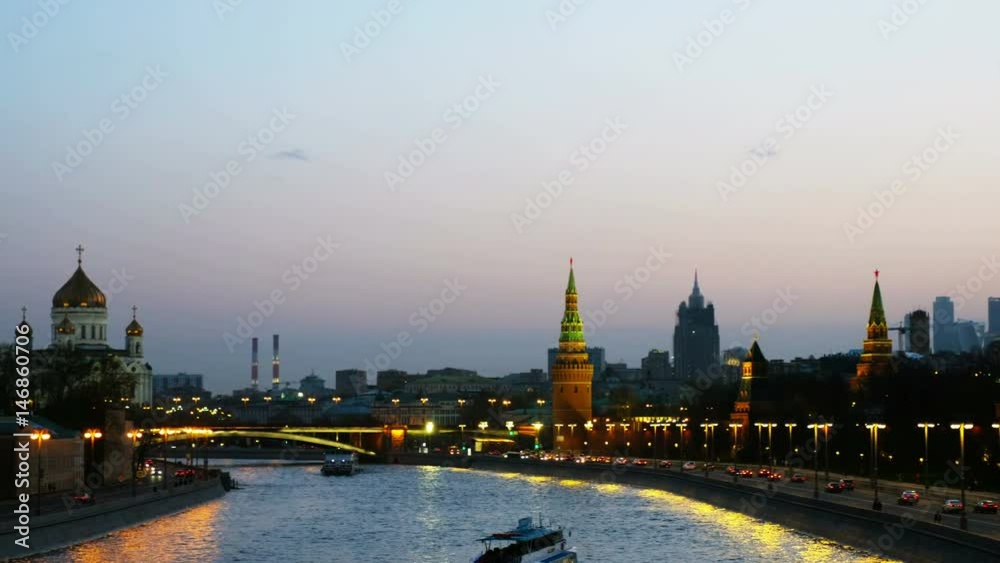 Moscow, Russia. Pan of popular landmark Kremlin in Moscow, Russia at night. Car traffic at the road. Illuminated Kremlin wall, and touristic boat at Moscow river at sunset Moscow, Russia. Pan of popular landmark Kremlin in Moscow, Russia at night. Car traffic at the road. Illuminated Kremlin wall, and touristic boat at Moscow river at sunset