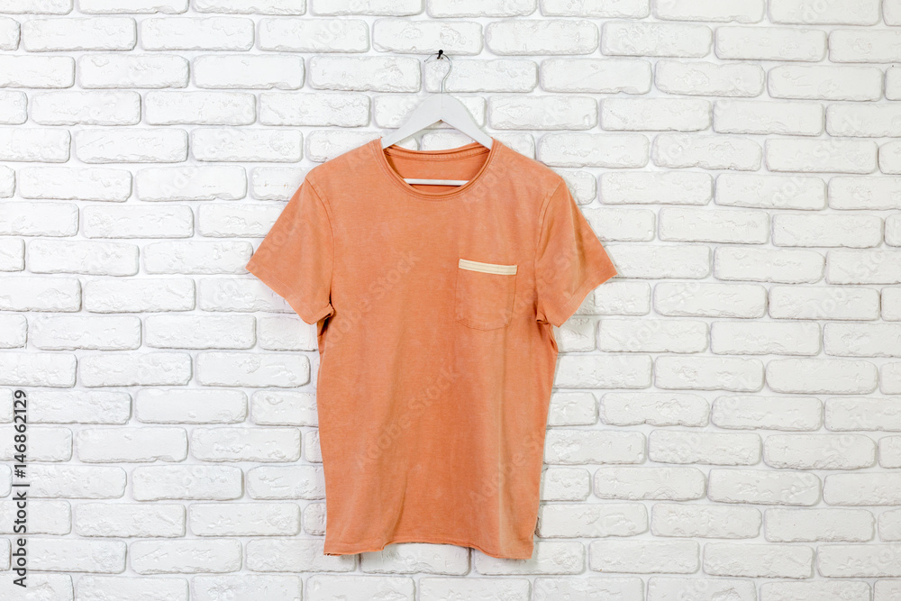 brick whitewashed wall with t-shirt on hanger brick whitewashed wall with t-shirt on hanger