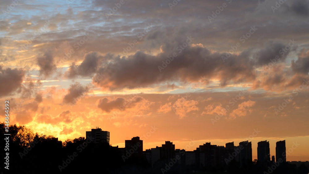 Silhouettes of residential buildings and colorful sunset.