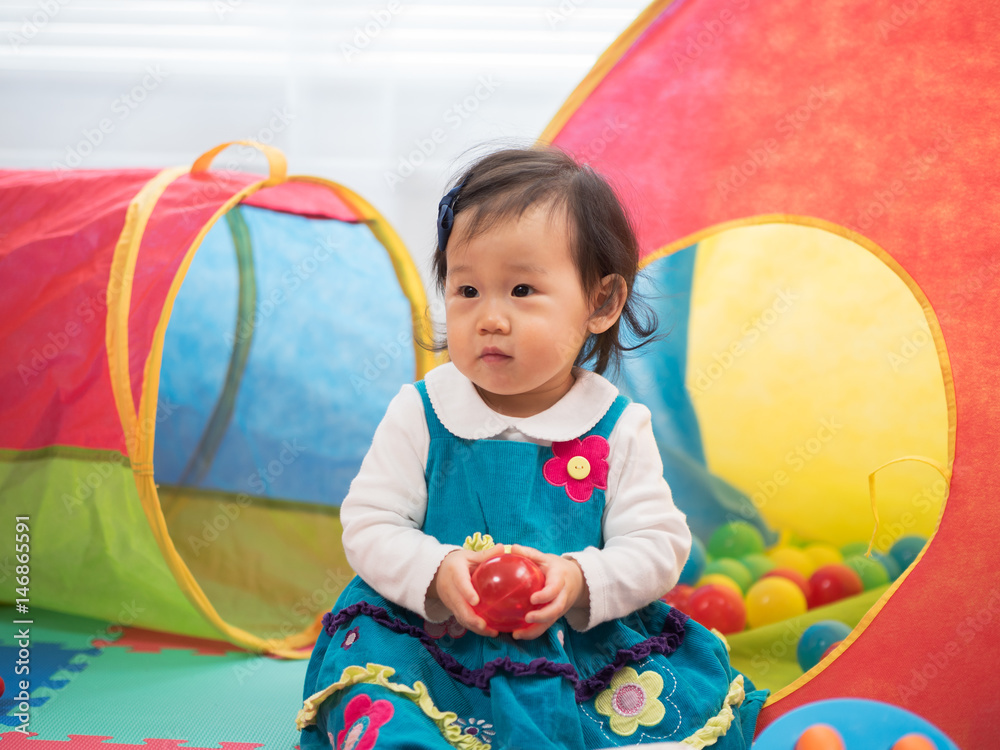 Obraz premium baby girl playing sea ball at home