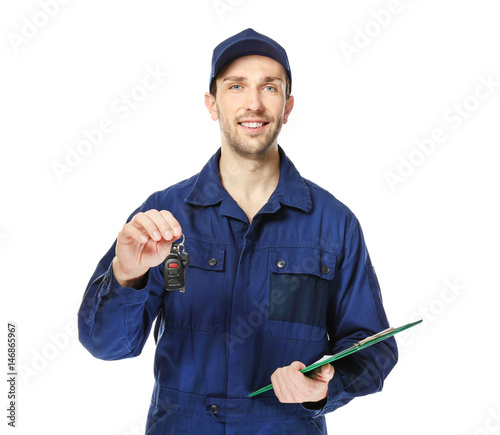 Handsome auto mechanic with car key and clipboard on white background photo