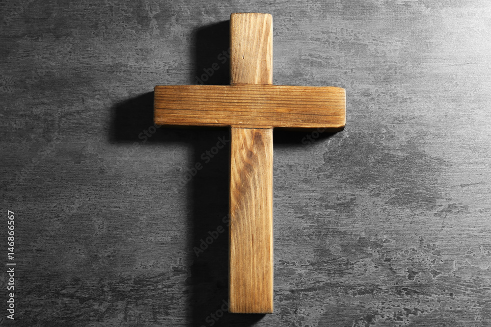 Wooden cross on gray background