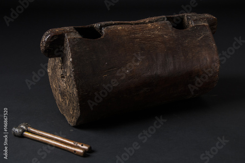 instrument of African music, drum made of wood with two bakets, isolated on dark background photo