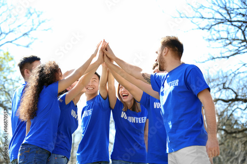 Group of volunteers in park on sunny day photo