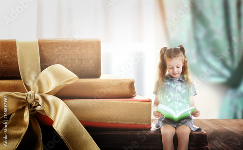 Cute girl reading book on w...