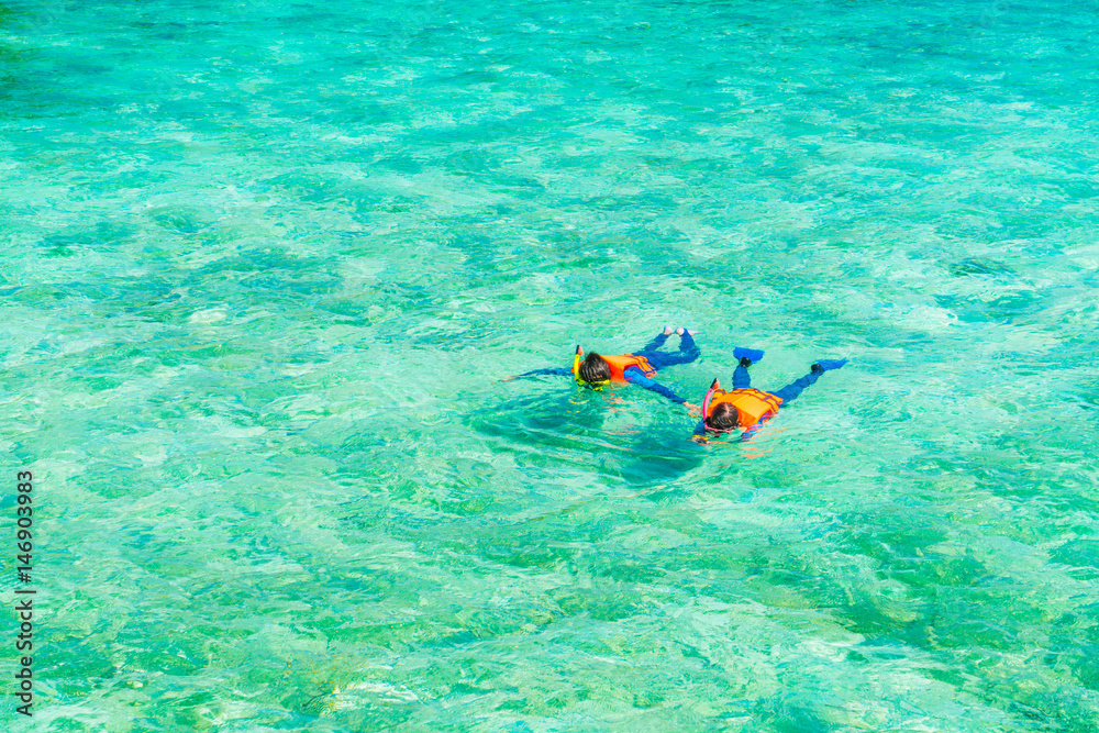 Couple snorkeling in tropical Maldives island .