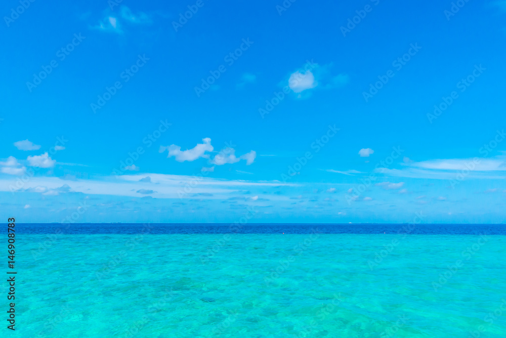White clouds with blue sky over calm sea in tropical Maldives island . White clouds with blue sky over calm sea in tropical Maldives island .