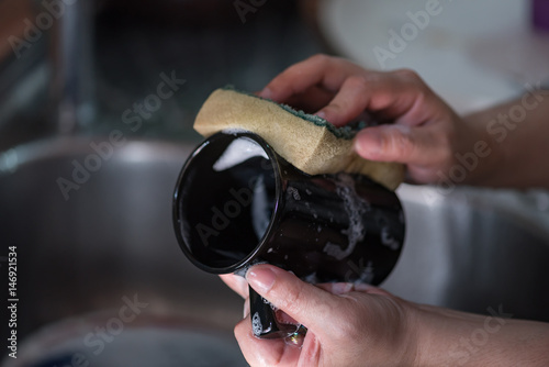 Washing black ceramic coffee cup