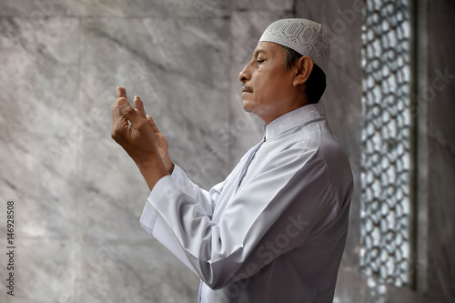 Old muslim man praying in mosque