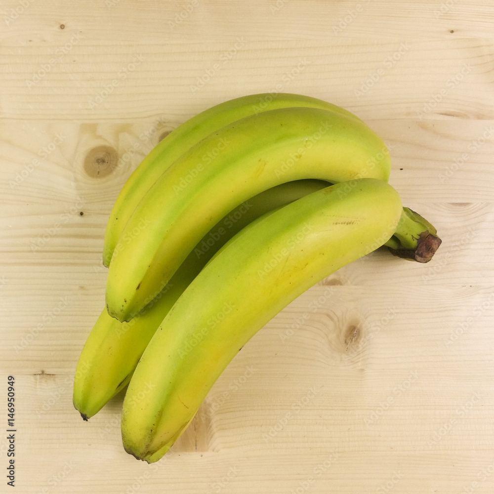 Bananas isolated on wooden background - top view - obrazy, fototapety, plakaty 