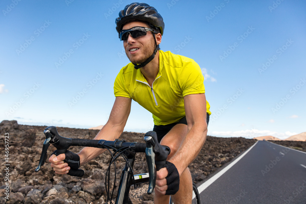 Fototapeta premium Cyclist man biking riding road bike training for triathlon. Biker on cardio workout on open road. Professional sports athlete living an active and healthy lifestyle.