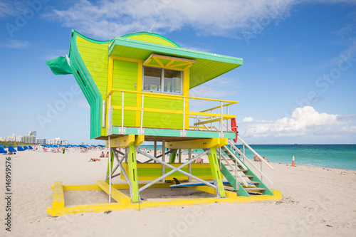 USA, FLORIDA, MIAMI BEACH. APRIL, 2017. Lifeguard tower in a colorful Art Deco style, with blue sky and Atlantic Ocean in the background. World famous travel location. South Beach.