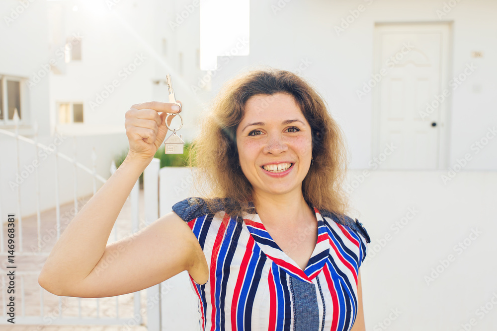 Concept of housewarming, real estate, property and moving - New home owner with key Concept of housewarming, real estate, property and moving - New home owner with key