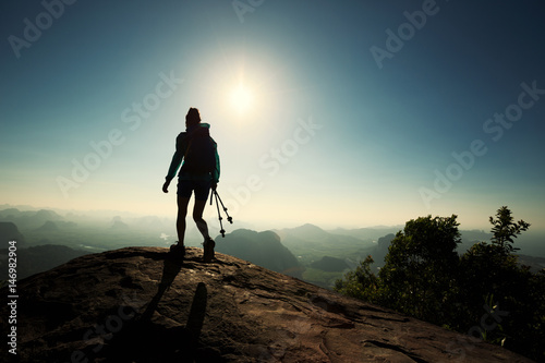 silhouette of woman backpacker hiking on sunrise mountain top