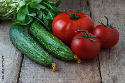 Cucumbers and tomatoes on a wooden background