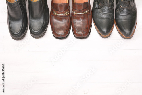 Traditional leather woman boots are on the wooden background.