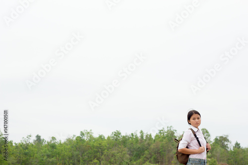 Backpacking girl.The backdrop is a green tree and white sky,copy space