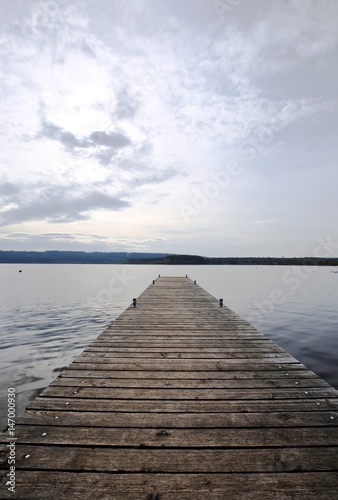 Bridge on the lake. Wooden plank lake pier. Long bridge on the lake 