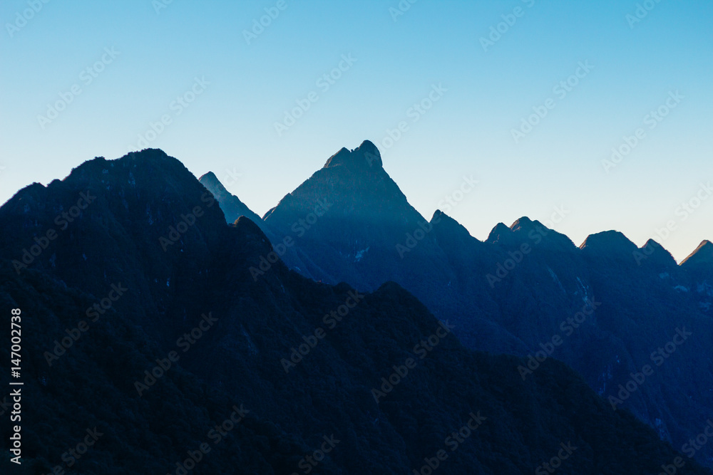 Fototapeta premium Colourful sunshine on a landscape of beautiful Fan Si Pan (Fansipan) or Phan Xi Pang mountain, the highest mountain in Indochina in Sapa, Hoang Lien National Park, Lao cai province northern Vietnam