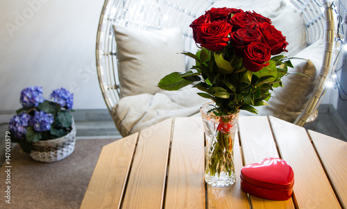 Atmospheric bouquet of roses with a heart-shaped chocolate box