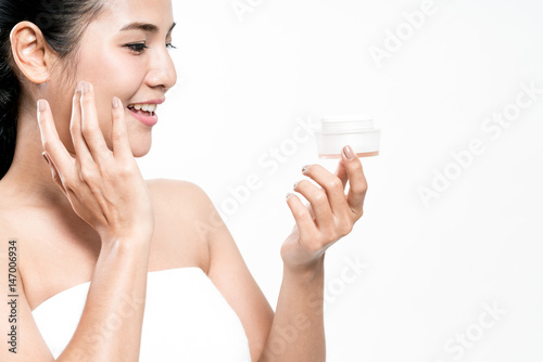 woman applying cosmetic cream treatment on her face.