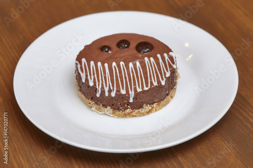 Round chocolate cake on plate, close up