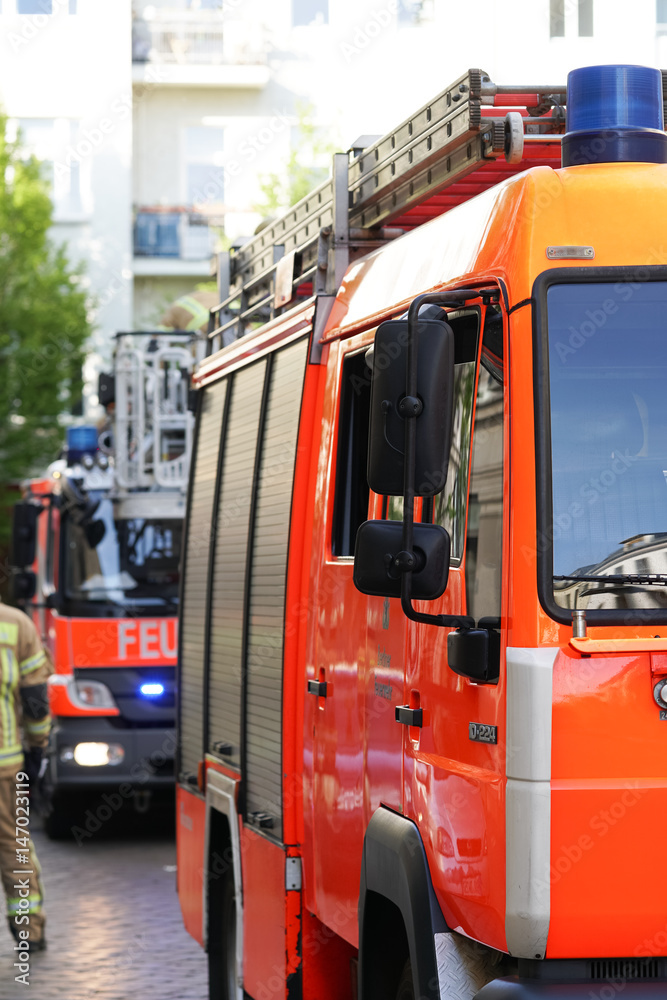 Fototapeta premium Berlin, Germany - April 30, 2017: fire department service truck and firemen. 112 is the single European emergency number that can be dialed free of charge is used for fire and medical emergency
