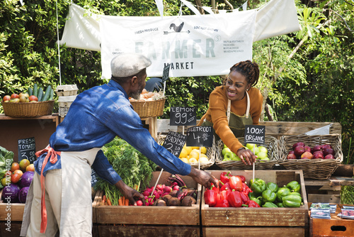 Fotografiet Greengrocer preparing organic fresh agricultural product at farmer market