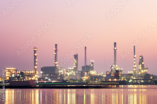 oil refinery industry at morning with water reflection.