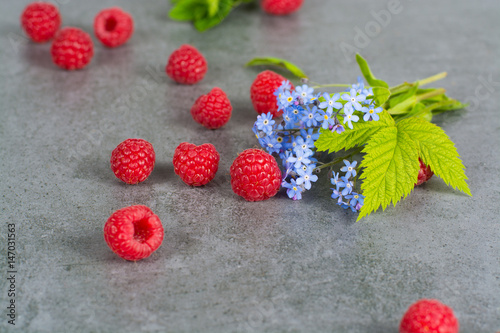 Sweet fresh raspberry with leaves, on grey background, copy space - summer colors photo