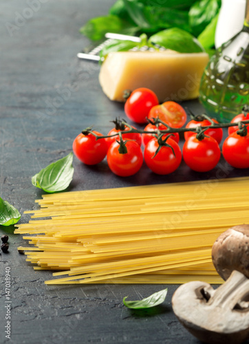 Set Italian ingredients for cooking pasta on a dark surface