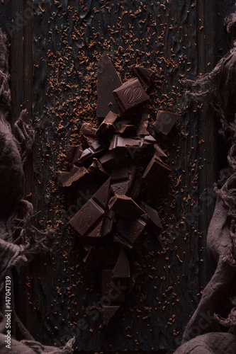 Bitter dark chocolate on a dark wooden background.