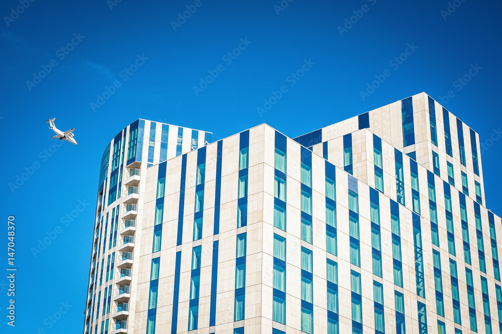 Beige and blue modern building landscape with airplane