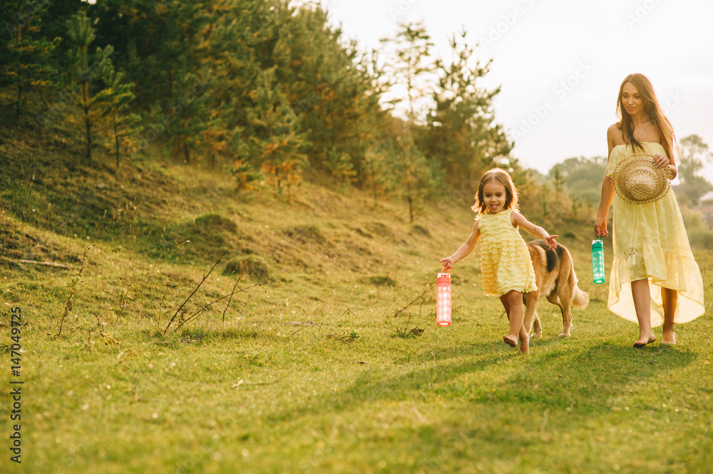 mother walk with his little daughter, and their dog mother walk with his little daughter, and their dog