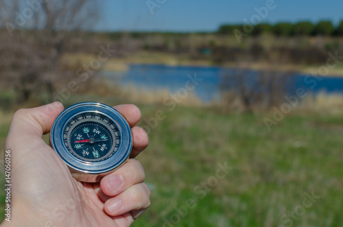 Man's hand holding a compass