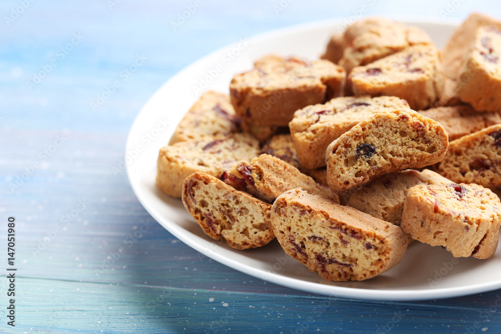Cantuccini cookies in plate on blue wooden table Cantuccini cookies in plate on blue wooden table