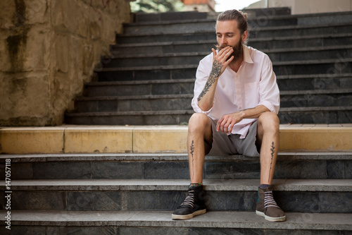 Tattoed and bearded guy posing outdoor in the city © DC Studio