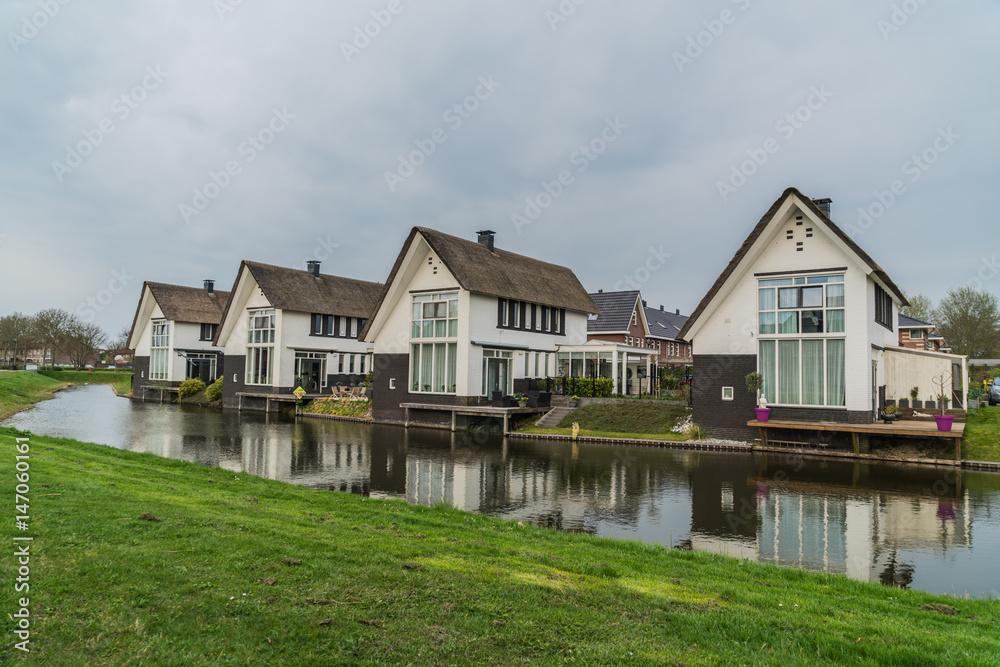 Row of houses with straw roofs in Lelystad, the Netherlands Row of houses with straw roofs in Lelystad, the Netherlands