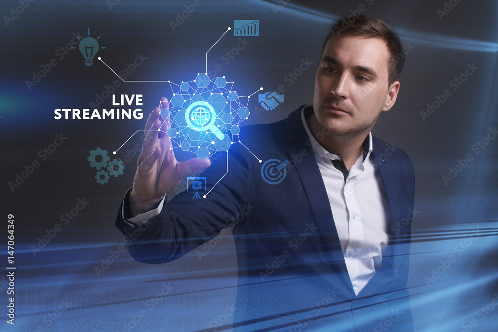 Business, Technology, Internet and network concept. Young businessman working on a virtual screen of the future and sees the inscription: Live streaming Business, Technology, Internet and network concept. Young businessman working on a virtual screen of the future and sees the inscription: Live streaming