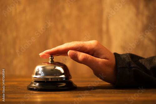 Businesswoman ringing hotel reception bell
