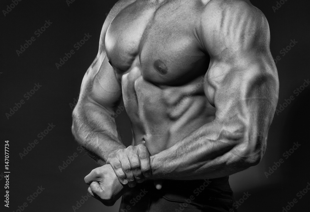 Portrait of strong healthy handsome Athletic Man Fitness Model posing near dark gray wall Portrait of strong healthy handsome Athletic Man Fitness Model posing near dark gray wall