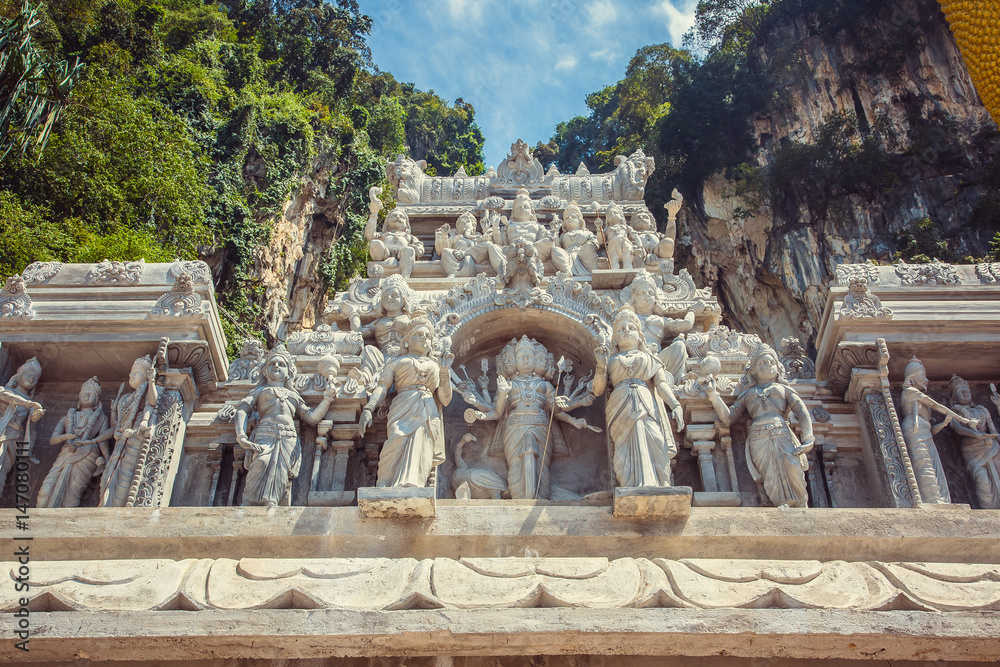 Figures of Hindu gods carved in stone on facade, Batu caves, Kuala Lumpur, Malaysia.