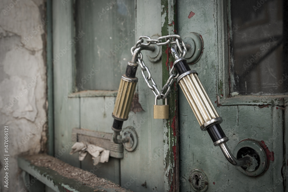 old wooden door locked with a padlock and a chain