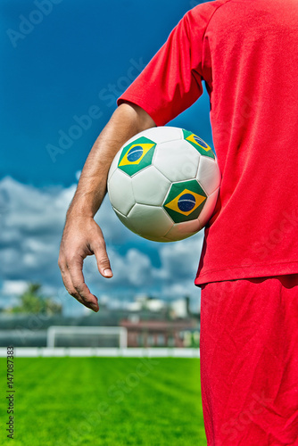 Soccer player holding ball © Microgen