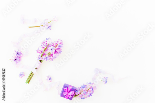 Bouquet of pink flowers, ring box and shabby tapes on white background. Flat lay, top view.