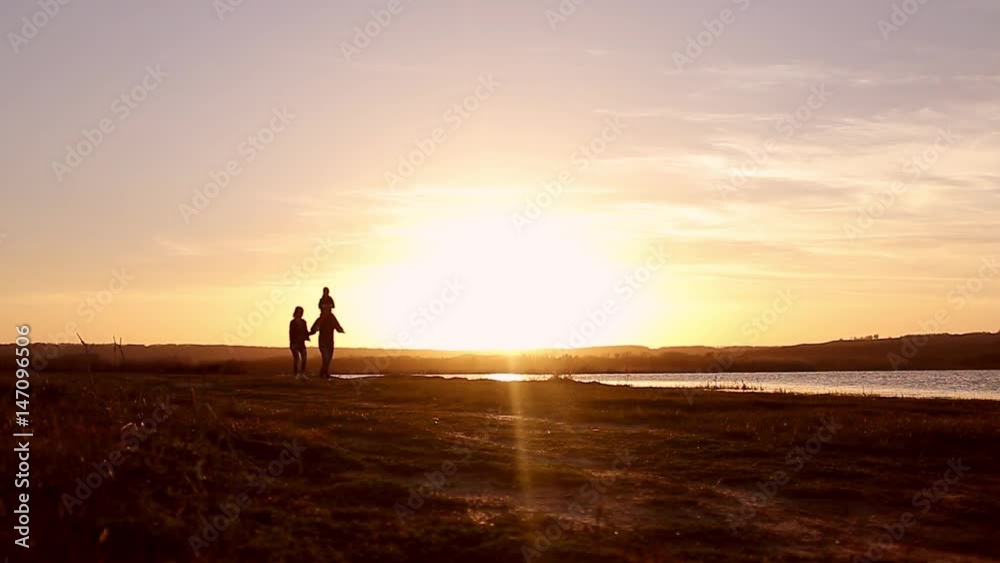 Silhouette, happy child with mother and father, family at sunset, summertime. Run, raising baby up in the air, hugs, love, playing. We are happy family. Silhouette, happy child with mother and father, family at sunset, summertime. Run, raising baby up in the air, hugs, love, playing. We are happy family.
